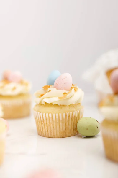 Foco seletivo de deliciosos cupcakes de Páscoa com ovos de codorna coloridos em cinza — Fotografia de Stock