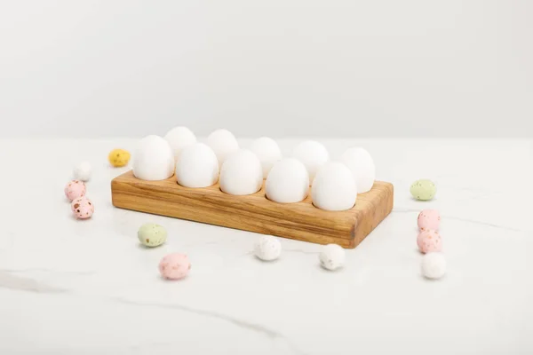 Colorful quail and chicken eggs on wooden board on grey background — Stock Photo