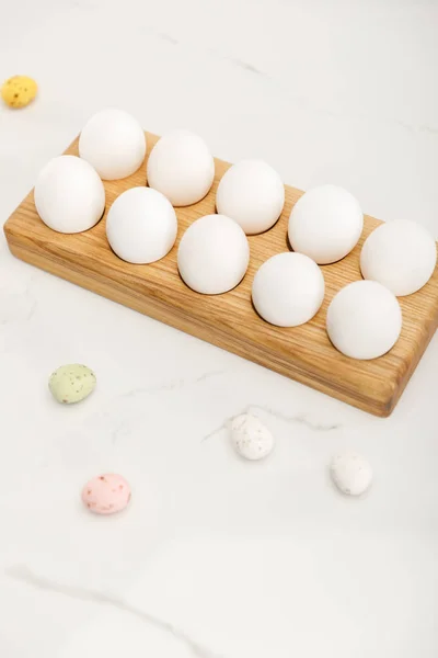Quaglia dipinta e uova di pollo su tavola di legno su sfondo bianco — Foto stock