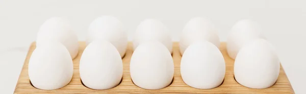 Plateau en bois avec œufs de poulet sur fond blanc, panoramique — Photo de stock