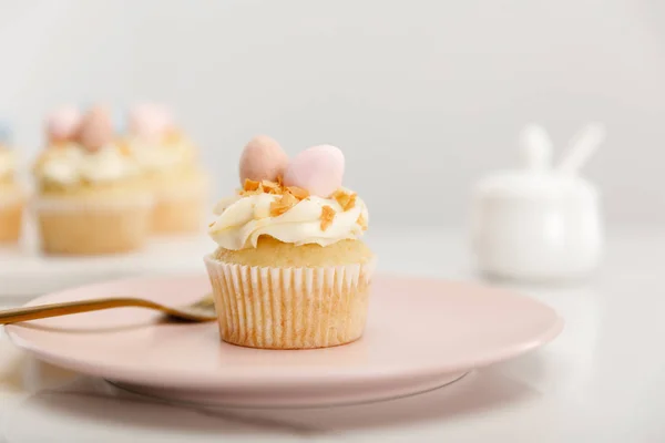 Selective focus of cupcake on plate with fork on grey background — Stock Photo