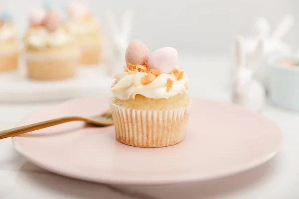 Selective focus of cupcake on plate with fork on grey background — Stock Photo