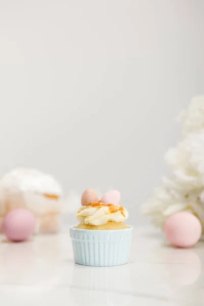 Foco seletivo de cupcake com ovos de Páscoa em fundo cinza — Fotografia de Stock