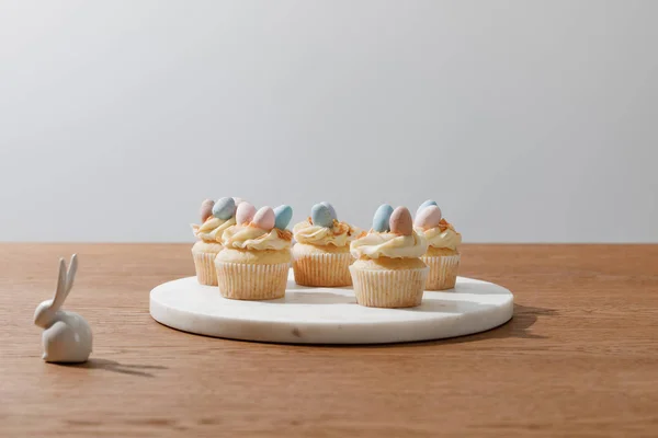 Cupcakes on round board isolated on grey — Stock Photo