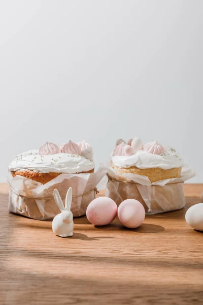 Lapins décoratifs, œufs de poulet et pain de Pâques isolés sur gris — Photo de stock