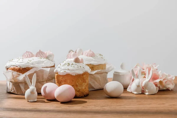 Lapins décoratifs, œufs de poulet, sucrier, gâteaux de Pâques et pétales isolés sur gris — Photo de stock