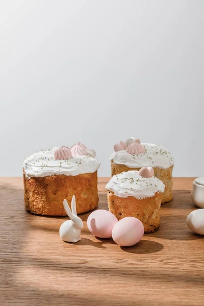 Декоративный кролик, куриные яйца, сахарная чаша с пасхальными тортами, изолированными на сером — стоковое фото