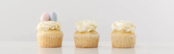 Délicieux cupcakes isolés sur fond gris, panoramique — Photo de stock