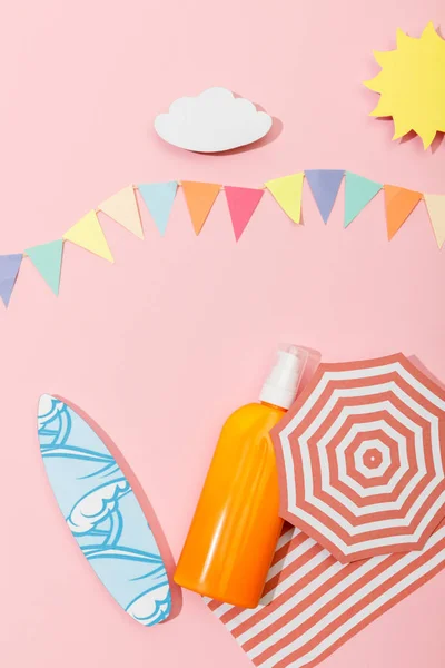 Draufsicht auf den papiergeschnittenen Strand mit Spenderflasche Sonnencreme auf rosa — Stockfoto