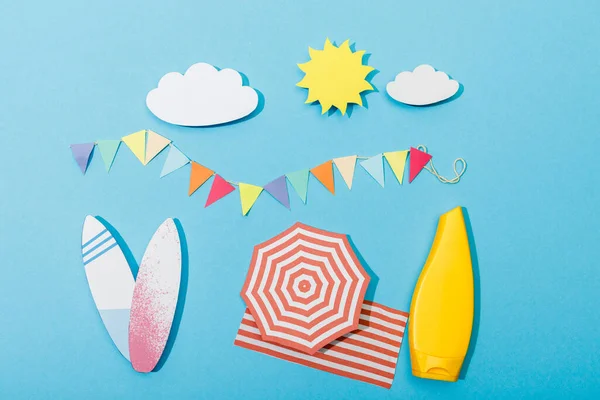 Top view of paper cut summer beach with surfboards and tube of sunscreen on blue — Stock Photo