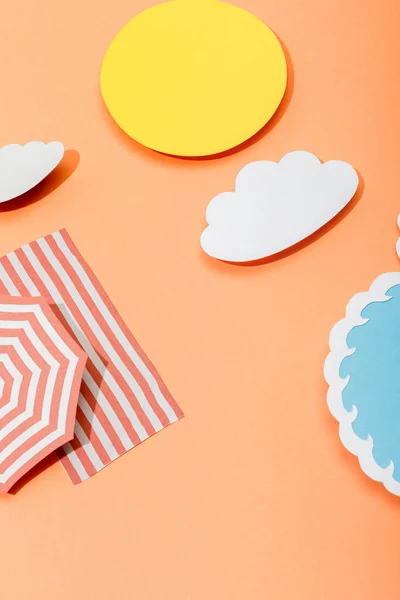 Papier coupé soleil, nuages, vague de la mer, parasol et couverture sur fond orange — Photo de stock