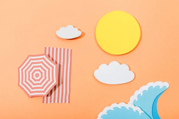 Vista dall'alto della spiaggia estiva di carta tagliata con ombrellone e coperta su sfondo arancione — Foto stock