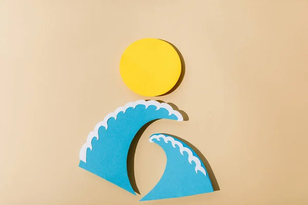 Top view of paper cut sun and sea waves on beige background — Stock Photo