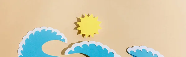 Вид сверху на вырезанное из бумаги солнце и морские волны на бежевом фоне, панорамный снимок — стоковое фото