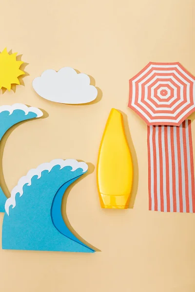 Top view of paper cut beach with yellow tube of sunscreen on beige — Stock Photo