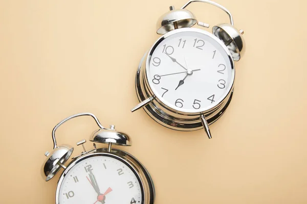 Top view of classic alarm clocks on beige background — Stock Photo