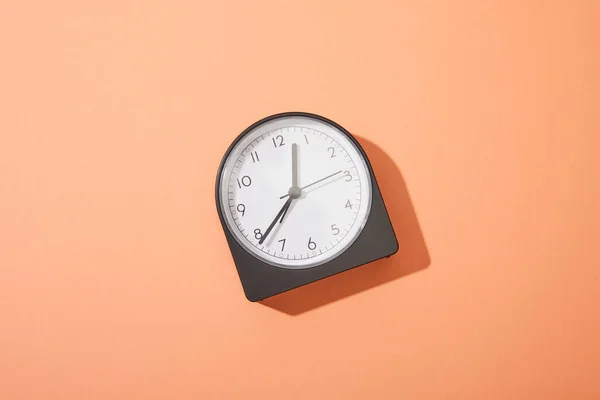 Vue de dessus de l'horloge sur fond de pêche — Photo de stock