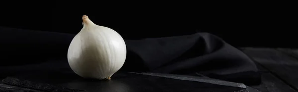 Plano panorámico de cebolla blanca entera sobre tablas de cortar oscuras aisladas en negro - foto de stock