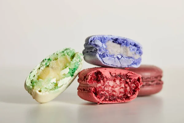 Selective focus of assorted delicious bitten colorful french macaroons on white background — Stock Photo