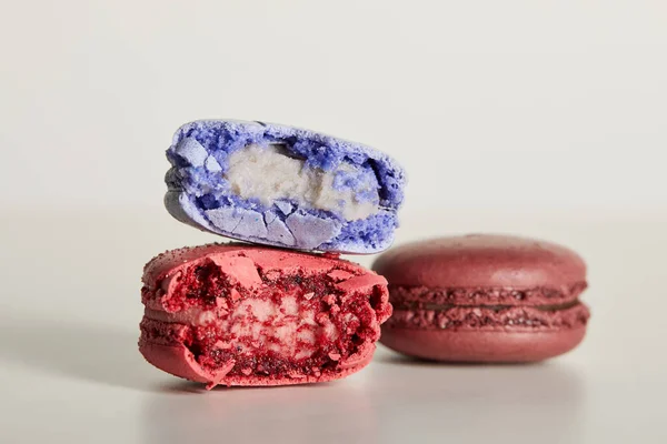 Messa a fuoco selettiva di assortiti deliziosi macaron francesi colorati morsi su sfondo bianco — Foto stock