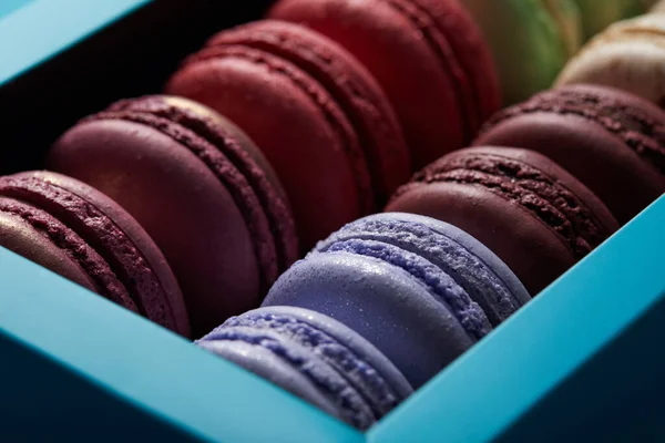 Vista de cerca de una variedad de deliciosos macarrones franceses coloridos en caja - foto de stock