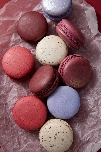 Top view of assorted delicious colorful french macaroons on crumpled paper — Stock Photo