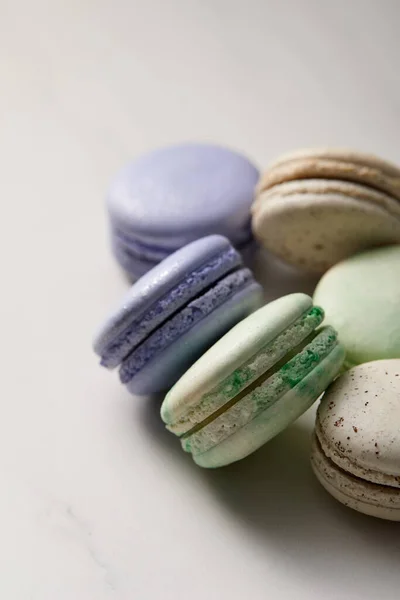 Close up view of assorted delicious green, violet and yellow french macaroons on grey background — Stock Photo