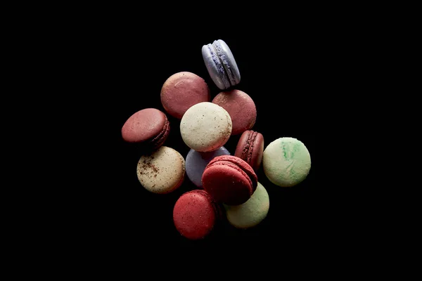 Top view of assorted delicious colorful french macaroons isolated on black — Stock Photo