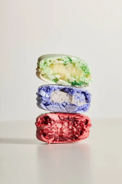 Assorted delicious bitten colorful french macaroons on white background — Stock Photo