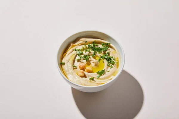Bowl with tasty hummus with chickpea and parsley on grey background — Stock Photo