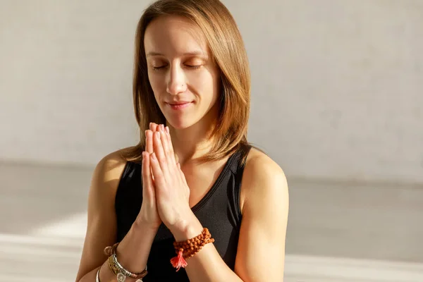 Happy woman with praying hands in yoga studio — Stock Photo
