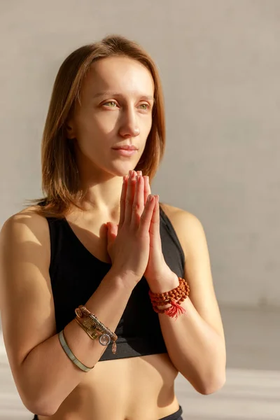 Belle femme avec des mains priantes méditant dans le studio de yoga — Photo de stock