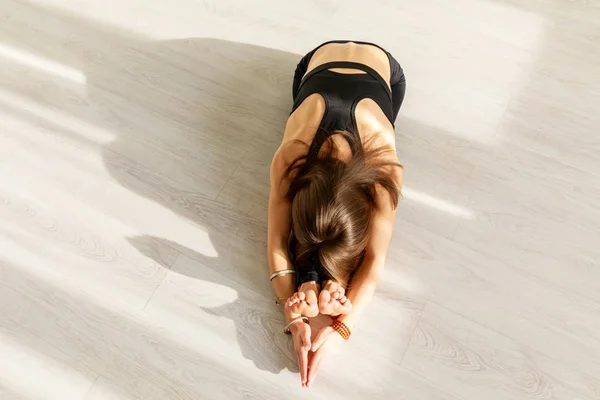 Над головой вид гибкой женщины, практикующей йогу на полу — стоковое фото