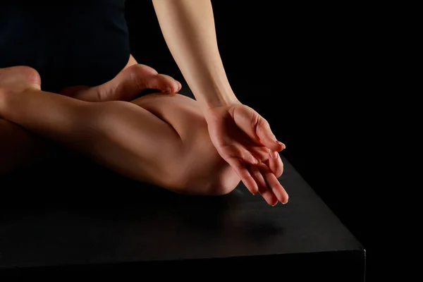 Обрезанный вид женщины в позе лотоса практикующей йогу изолированной на черном — стоковое фото