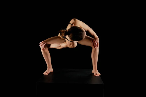 Девушка с босиком делает вращающийся боковой угол упражнения изолированы на черном — стоковое фото
