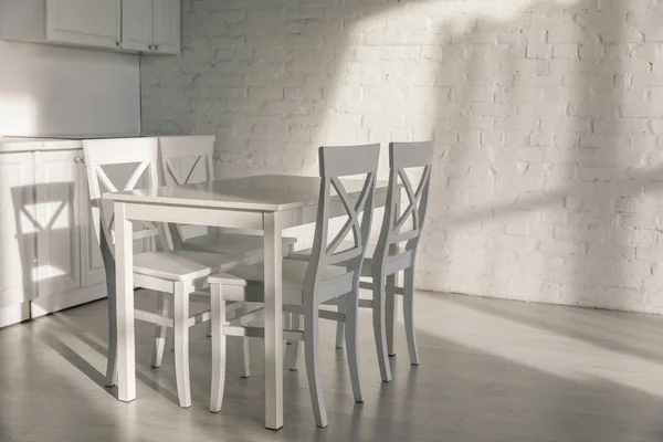 Sunlight near chairs near table in modern kitchen — Stock Photo
