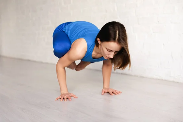 Flexibles Mädchen in blauer Sportbekleidung in Krähen-Pose — Stockfoto