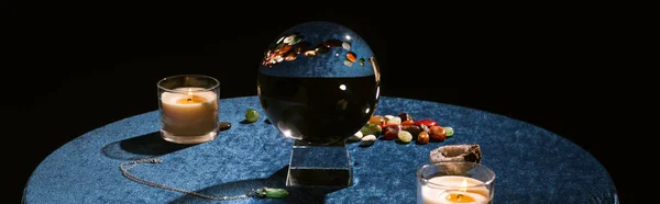 Crystal ball, candle and fortune telling stones on dark blue velour cloth, panoramic shot — Stock Photo