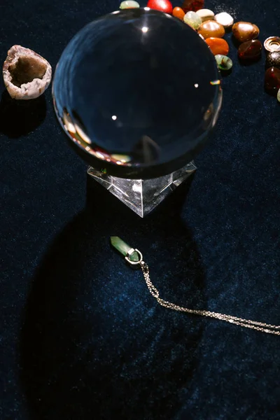 Crystal ball and fortune telling stones on dark blue velour cloth — Stock Photo