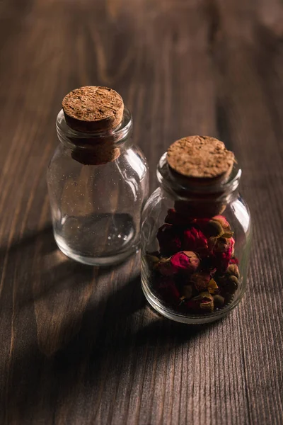 Foco seletivo de frascos com botões em fundo de madeira — Fotografia de Stock