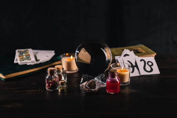 KYIV, UKRAINE - 9 JANVIER 2020 : mise au point sélective de boule de cristal, de livres et d'objets occultes sur fond bois et noir — Photo de stock