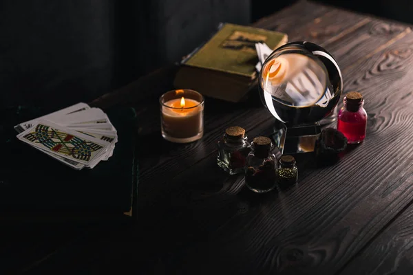 KYIV, UKRAINE - JANUARY 9, 2020: selective focus of crystal ball near occult and mystical objects on table on dark background — Stock Photo