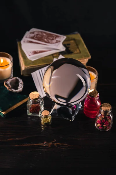 KYIV, UKRAINE - JANUARY 9, 2020: selective focus of crystal ball with books and occult objects on wooden and black background — Stock Photo