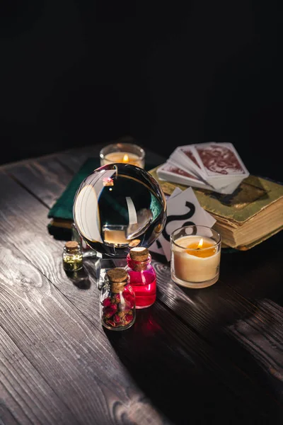 KYIV, UKRAINE - JANUARY 9, 2020: selective focus of crystal ball, candles and occult objects on wooden and black background — Stock Photo