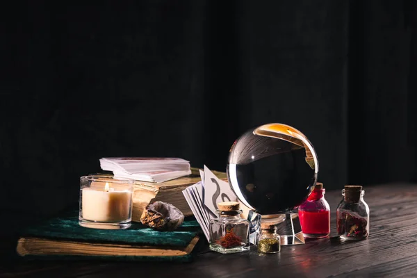 KYIV, UKRAINE - JANUARY 9, 2020: crystal ball with occult and mystical objects on wooden and black background — Stock Photo