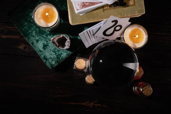 KYIV, UKRAINE - JANUARY 9, 2020: top view of candles, books and occult objects on wooden background — Stock Photo