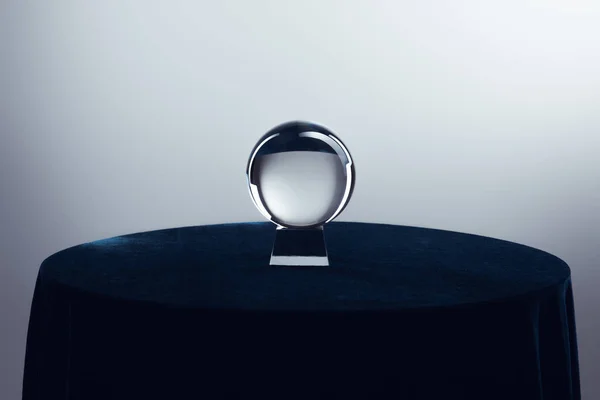 Bola de cristal sobre mesa redonda sobre fondo gris — Stock Photo