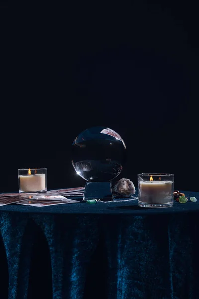 QUIIV, UCRÂNIA - JANEIRO 9, 2020: bola de cristal com objetos ocultos em mesa redonda isolada em preto — Fotografia de Stock