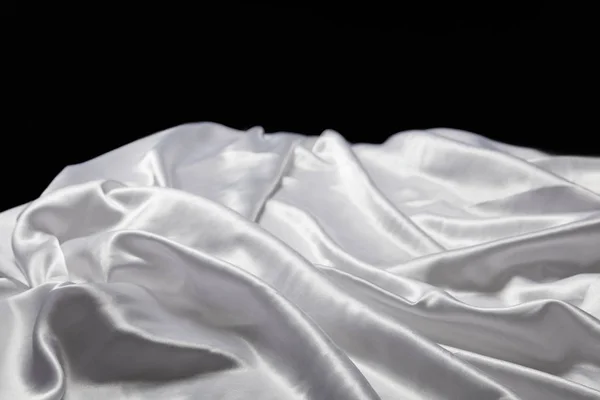 Vue rapprochée de tissu texturé blanc doux et froissé en soie isolé sur noir — Photo de stock