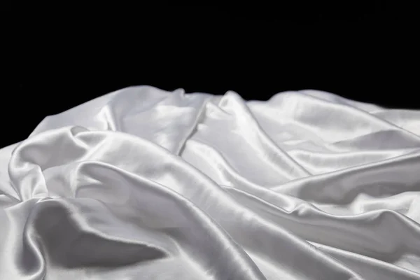 Vista de cerca de blanco suave y arrugado tela texturizada de seda aislado en negro — Stock Photo